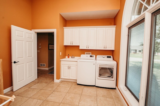 241 Cottonwood Cv, Lynd, MN 56157 - washroom featuring visible vents, a sink, washer and clothes dryer, cabinet space, and light tile patterned floors