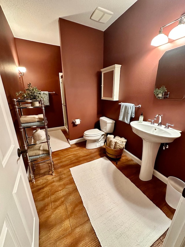 241 Cottonwood Cv, Lynd, MN 56157 - full bathroom with baseboards, toilet, and wood finished floors
