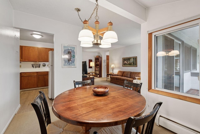 dining room featuring baseboards, a baseboard radiator, light wood-style flooring, and a chandelier