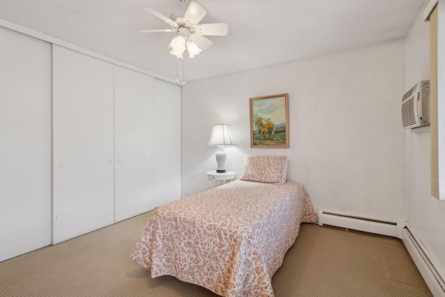 bedroom with an AC wall unit, a closet, carpet, and a baseboard radiator