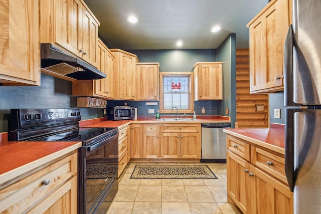 kitchen featuring a sink, appliances with stainless steel finishes, light brown cabinets, and under cabinet range hood