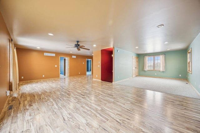 unfurnished living room featuring ceiling fan, visible vents, recessed lighting, wood finished floors, and baseboards