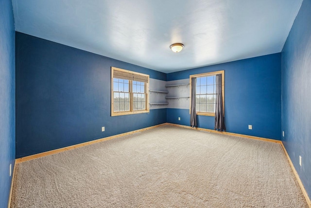 empty room featuring carpet floors and baseboards