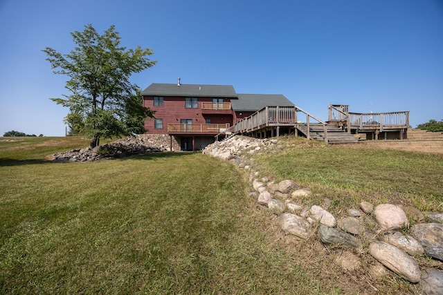 rear view of house featuring a deck and a lawn