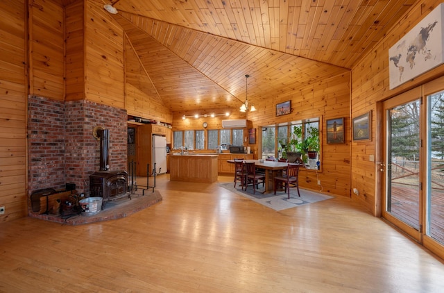 34130 Deer Lake Rd, Grand Rapids, MN 55744 - dining area with high vaulted ceiling, a wood stove, light wood-style floors, wooden walls, and wood ceiling
