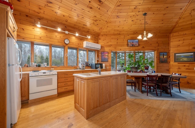 34130 Deer Lake Rd, Grand Rapids, MN 55744 - kitchen with white appliances, a wall unit AC, vaulted ceiling, light countertops, and light wood-style flooring