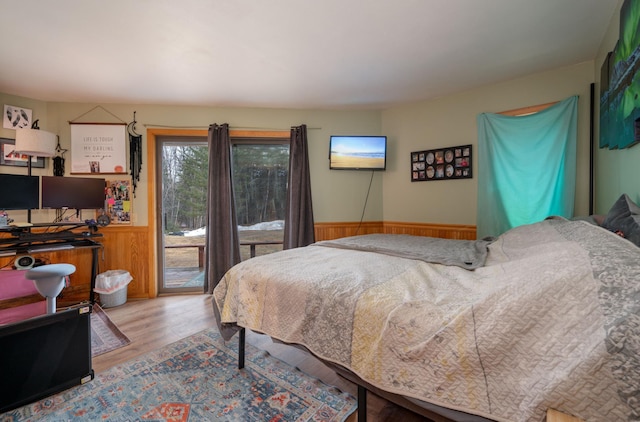 34130 Deer Lake Rd, Grand Rapids, MN 55744 - bedroom with access to exterior, a wainscoted wall, and light wood-style flooring