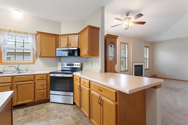 kitchen featuring stainless steel appliances, a sink, a peninsula, and light countertops