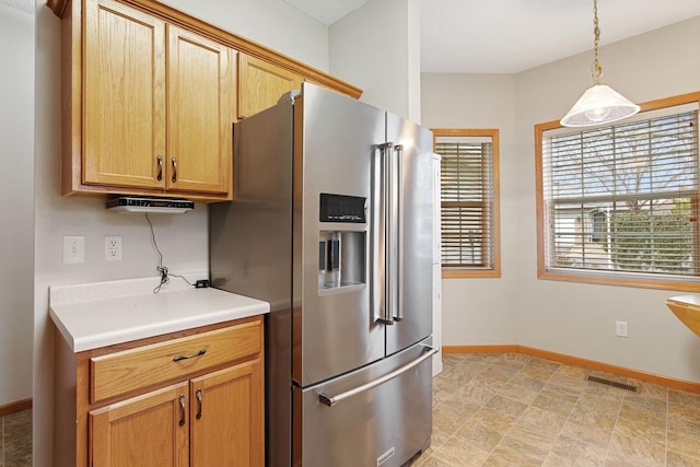kitchen with high end refrigerator, light countertops, decorative light fixtures, and baseboards