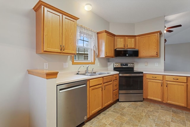 kitchen with appliances with stainless steel finishes, a sink, light countertops, and a ceiling fan