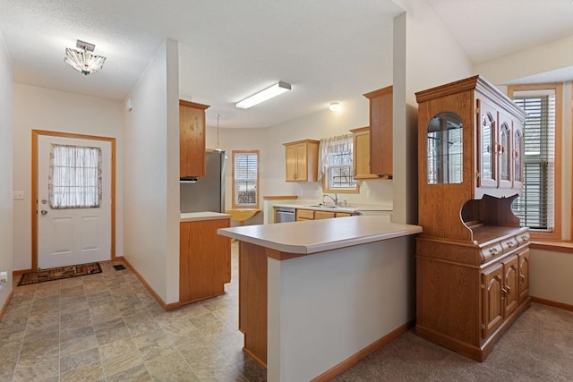 kitchen with light countertops, baseboards, healthy amount of natural light, and a peninsula