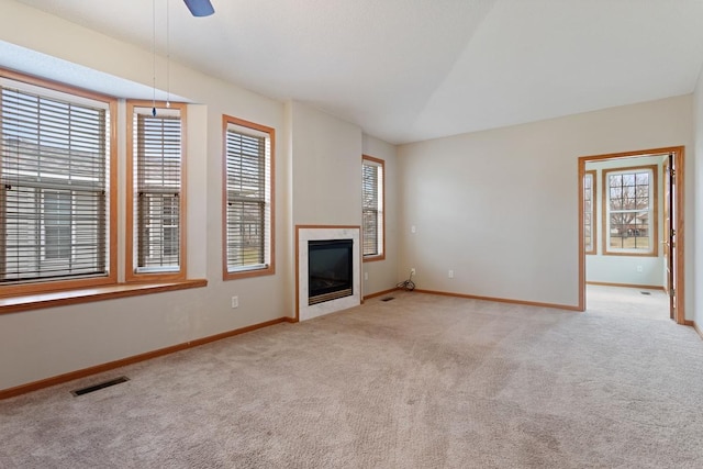 unfurnished living room featuring carpet floors, healthy amount of natural light, and baseboards