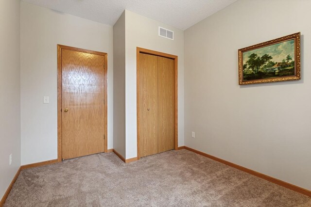 unfurnished bedroom with carpet, a closet, and baseboards