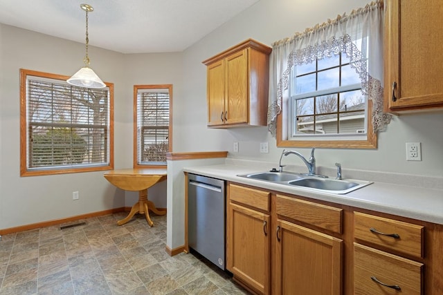 kitchen with stainless steel dishwasher, a sink, healthy amount of natural light, and baseboards