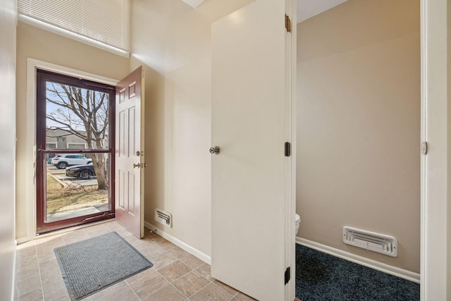 foyer entrance featuring visible vents, baseboards, and light tile patterned flooring