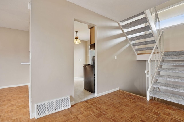 stairway featuring visible vents and baseboards