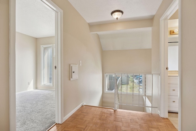 interior space featuring a textured ceiling and baseboards