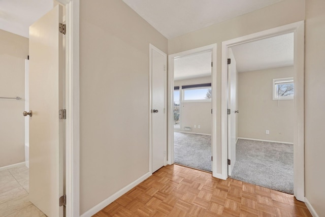 hall with a healthy amount of sunlight and baseboards