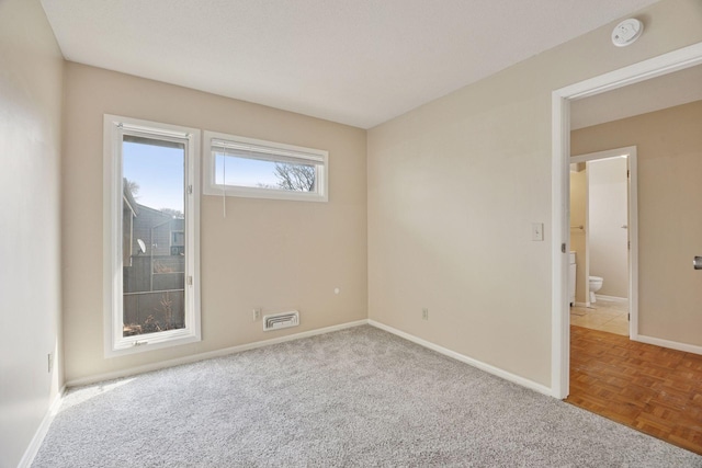 spare room featuring visible vents and baseboards