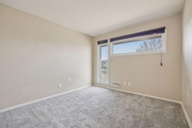 spare room featuring carpet and baseboards