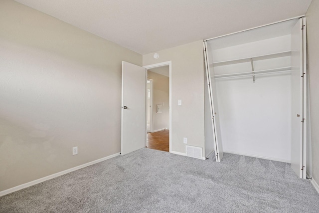 unfurnished bedroom featuring a closet, baseboards, visible vents, and carpet floors