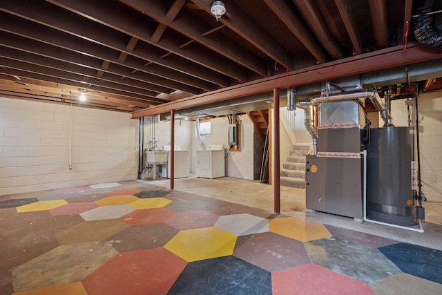 unfinished below grade area with a sink, heating unit, stairway, washing machine and clothes dryer, and gas water heater