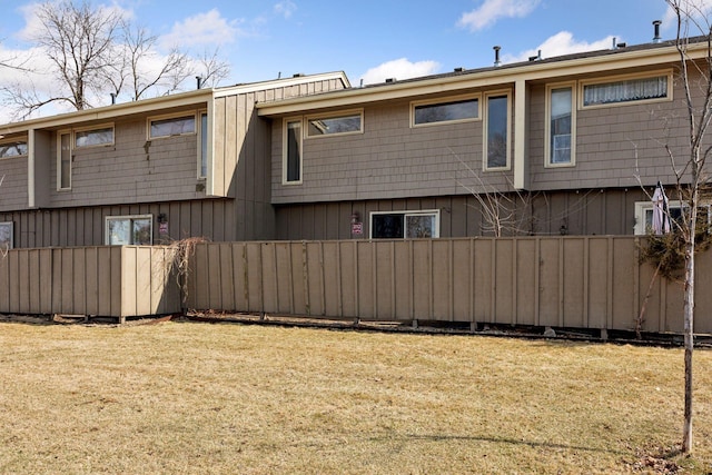 back of property with a yard and fence