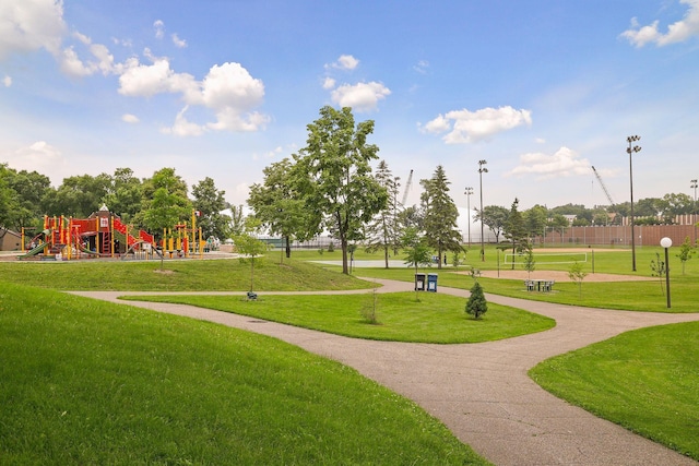 surrounding community with playground community and a lawn