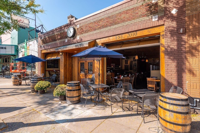exterior space with a patio, brick siding, and french doors