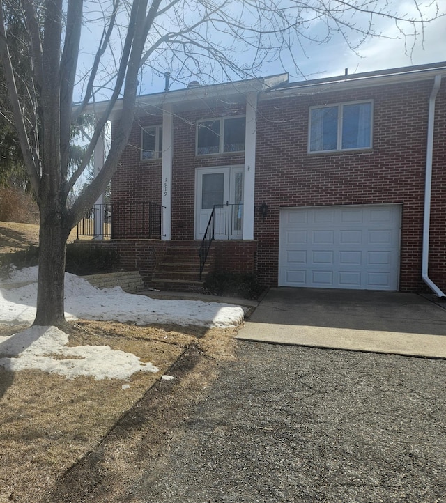 view of front facade featuring driveway, a garage, and brick siding