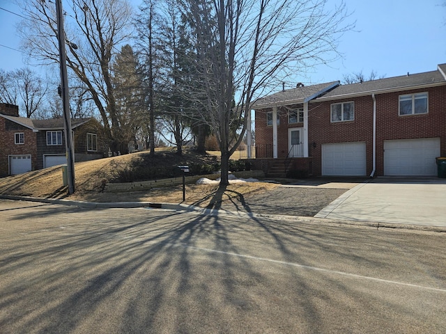 exterior space with brick siding, a garage, and concrete driveway