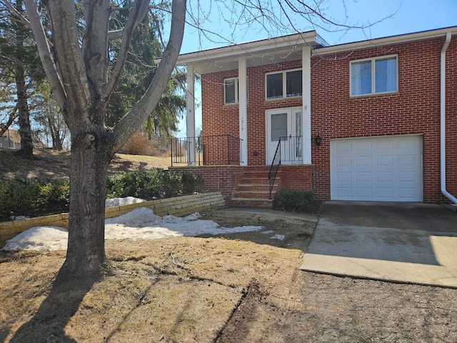 view of front of house with brick siding, a garage, and concrete driveway