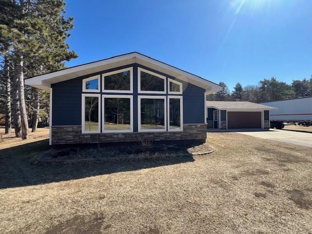 view of front of property with a garage, concrete driveway, and stone siding