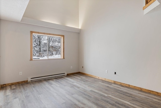 1607 7th Ave, Grand Rapids, MN 55744 - spare room featuring baseboard heating, wood finished floors, and baseboards