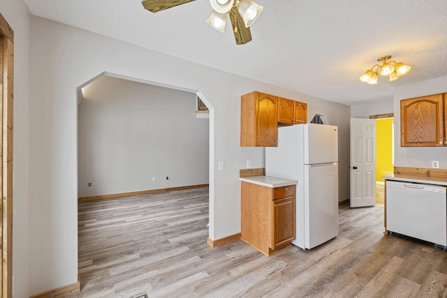 1607 7th Ave, Grand Rapids, MN 55744 - kitchen with white appliances, arched walkways, light countertops, light wood-style floors, and a textured ceiling