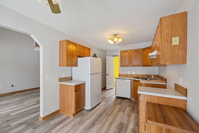 1607 7th Ave, Grand Rapids, MN 55744 - kitchen featuring white appliances, light wood-style flooring, light countertops, a sink, and brown cabinetry