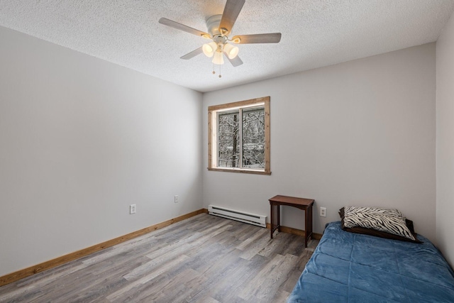 1607 7th Ave, Grand Rapids, MN 55744 - bedroom featuring a baseboard radiator, wood finished floors, a textured ceiling, baseboards, and a ceiling fan