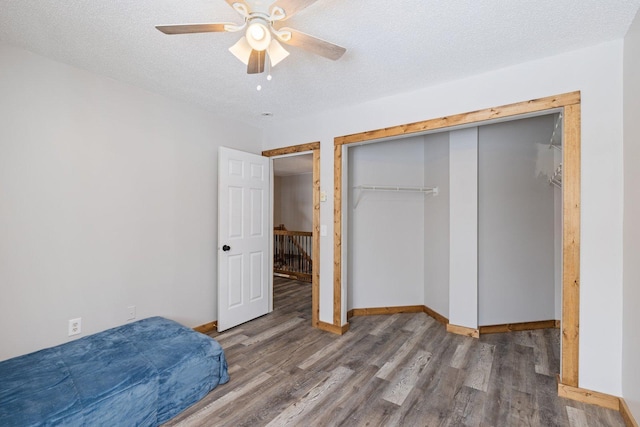 1607 7th Ave, Grand Rapids, MN 55744 - unfurnished bedroom featuring wood finished floors, a closet, baseboards, a ceiling fan, and a textured ceiling