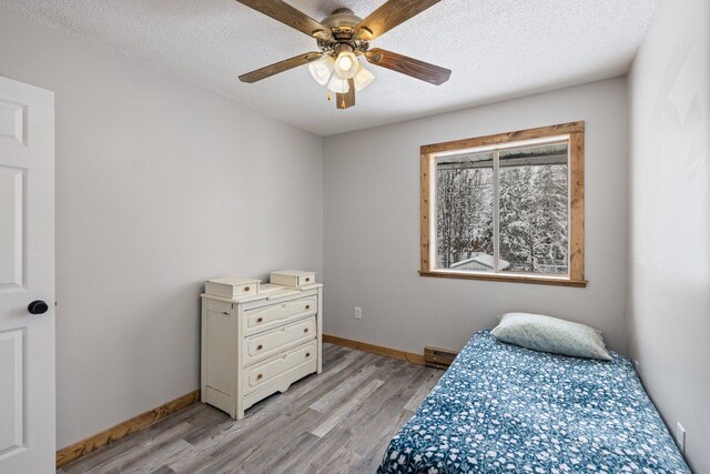 1607 7th Ave, Grand Rapids, MN 55744 - bedroom with light wood-style floors, baseboards, a textured ceiling, and ceiling fan