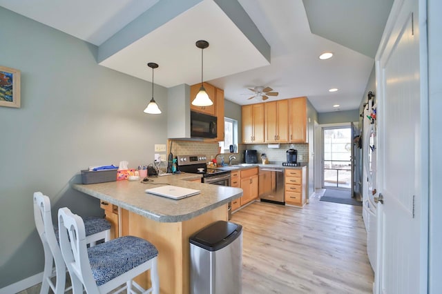 kitchen featuring a peninsula, plenty of natural light, a sink, and appliances with stainless steel finishes