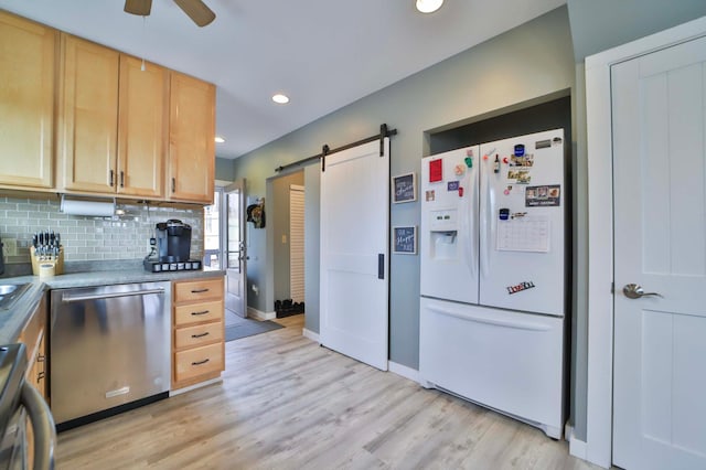 kitchen with stainless steel dishwasher, a barn door, baseboards, white refrigerator with ice dispenser, and ceiling fan