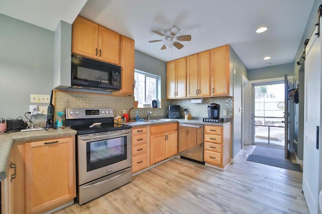 kitchen with a ceiling fan, a sink, stainless steel appliances, light wood-style flooring, and backsplash