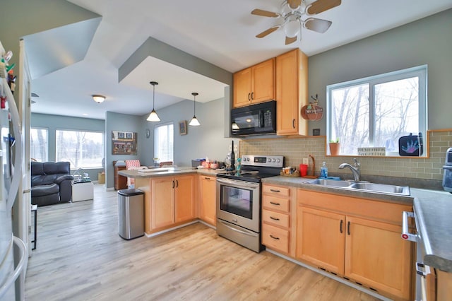 kitchen featuring light brown cabinets, a sink, black microwave, stainless steel electric range, and a peninsula
