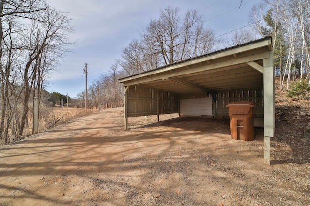 view of parking / parking lot featuring a detached carport and driveway
