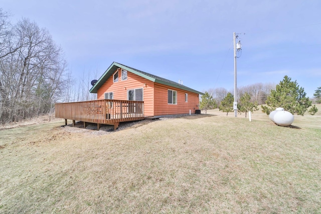 exterior space featuring a wooden deck, a yard, and faux log siding