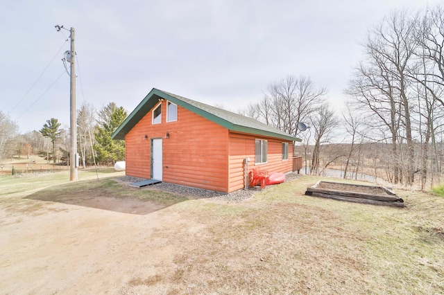 view of home's exterior featuring log veneer siding and a yard