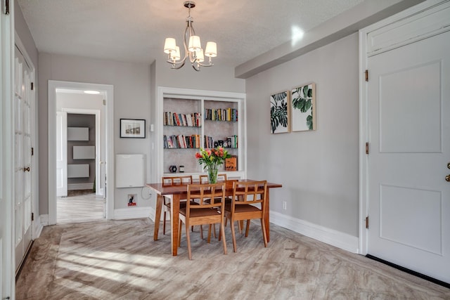 79 Western Ave N Unit 100, Saint Paul, MN 55102 - dining space featuring a chandelier, baseboards, a textured ceiling, and light wood-style floors