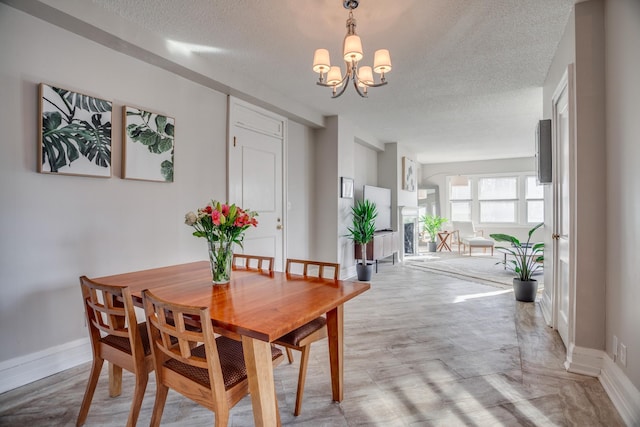 79 Western Ave N Unit 100, Saint Paul, MN 55102 - dining room featuring a textured ceiling, a chandelier, and baseboards