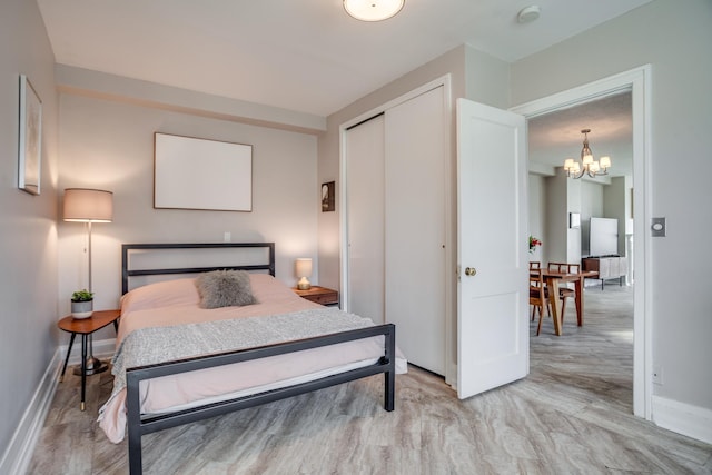 79 Western Ave N Unit 100, Saint Paul, MN 55102 - bedroom featuring a chandelier, baseboards, a closet, and light wood finished floors