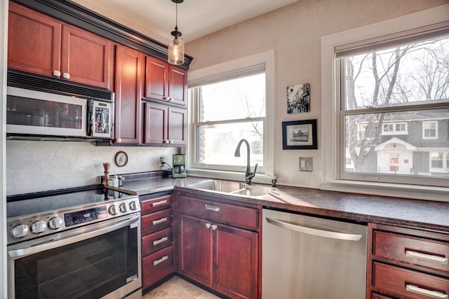 79 Western Ave N Unit 100, Saint Paul, MN 55102 - kitchen featuring stainless steel appliances, a sink, dark countertops, pendant lighting, and dark brown cabinets